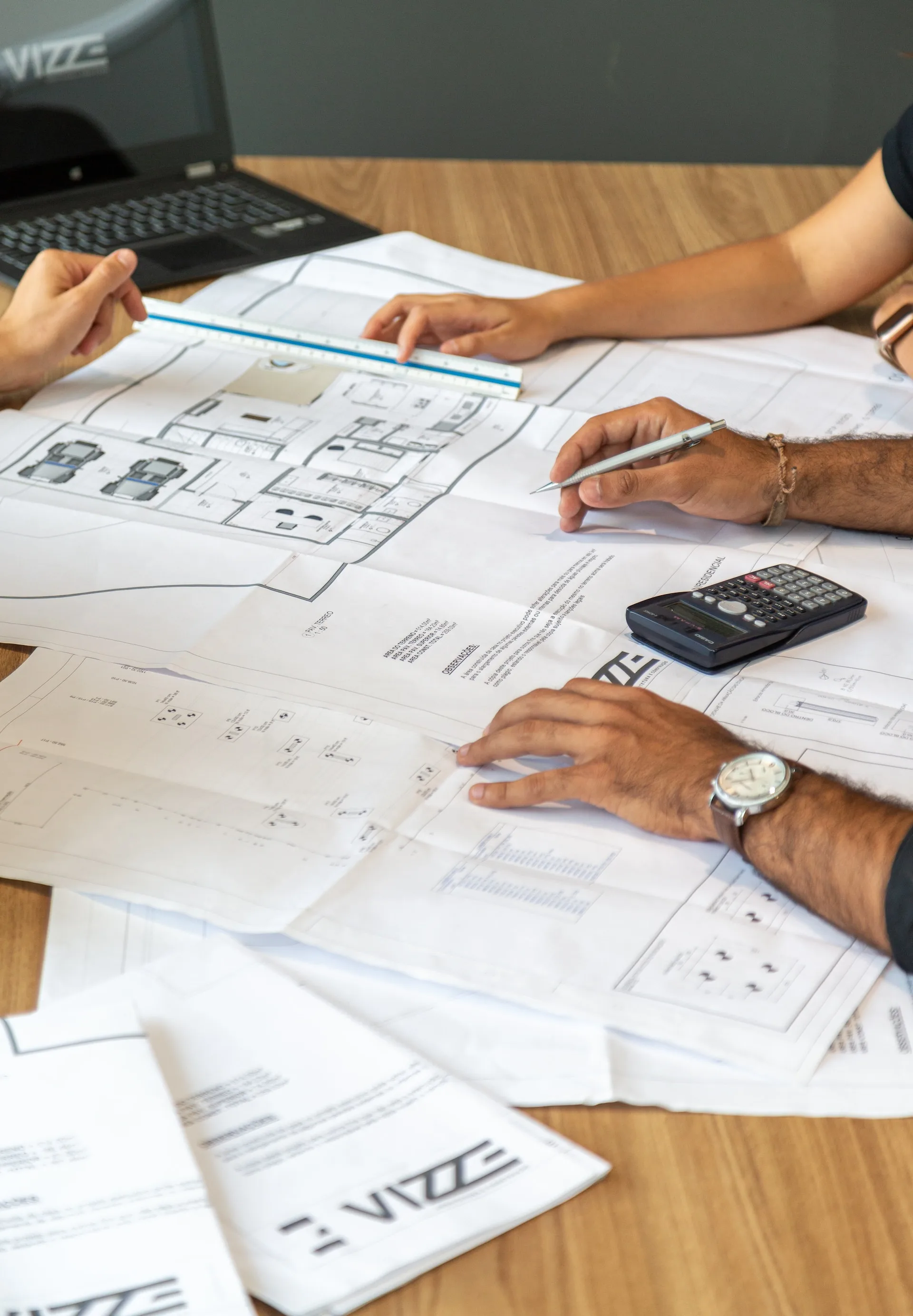 Hands on a table with plans
